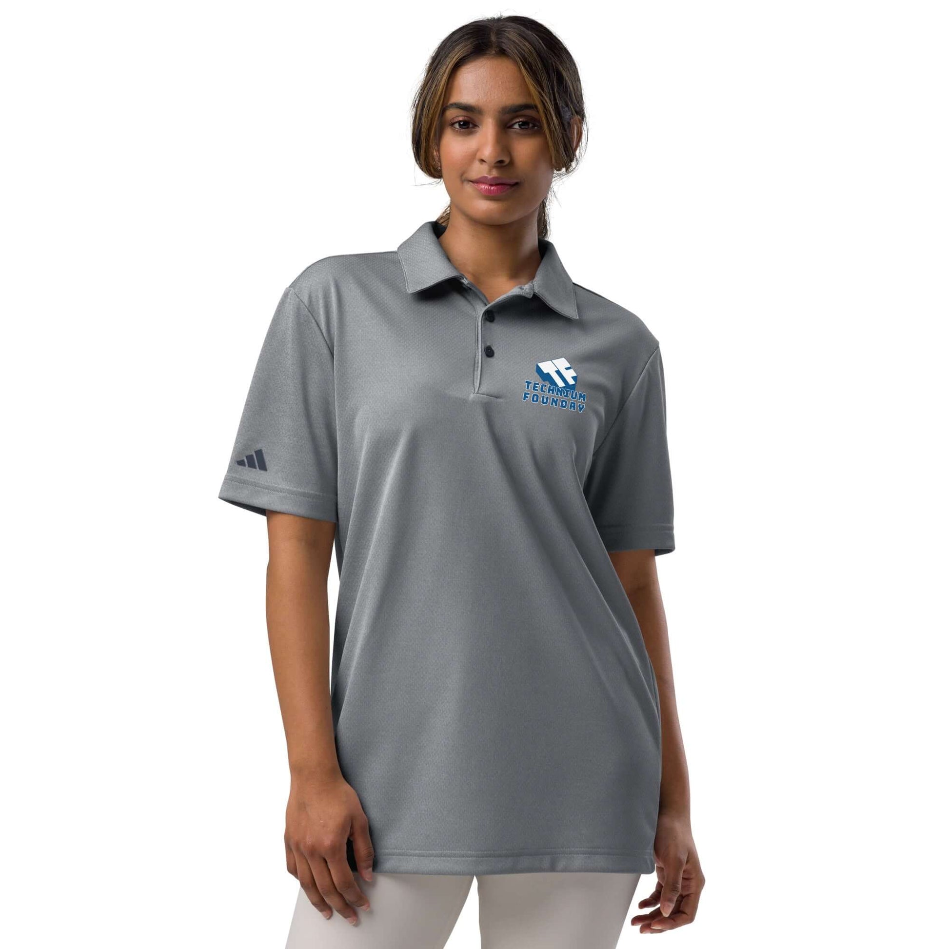 Woman wearing Adidas Tennis Serve Polo in gray, featuring Spin Science design for athletic performance and style.