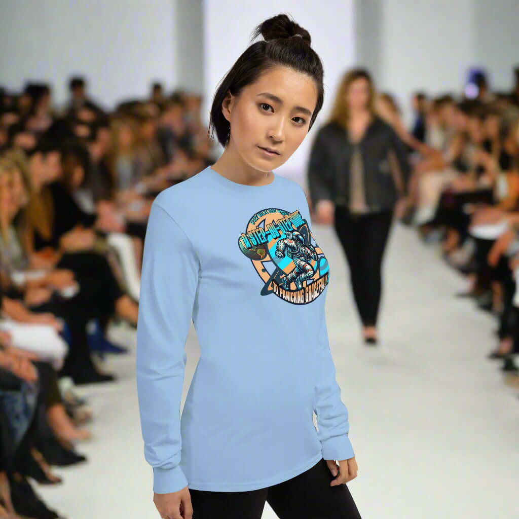 Model wearing Space Walks Gone Wrong long sleeve tee with vintage astronaut design at fashion show.