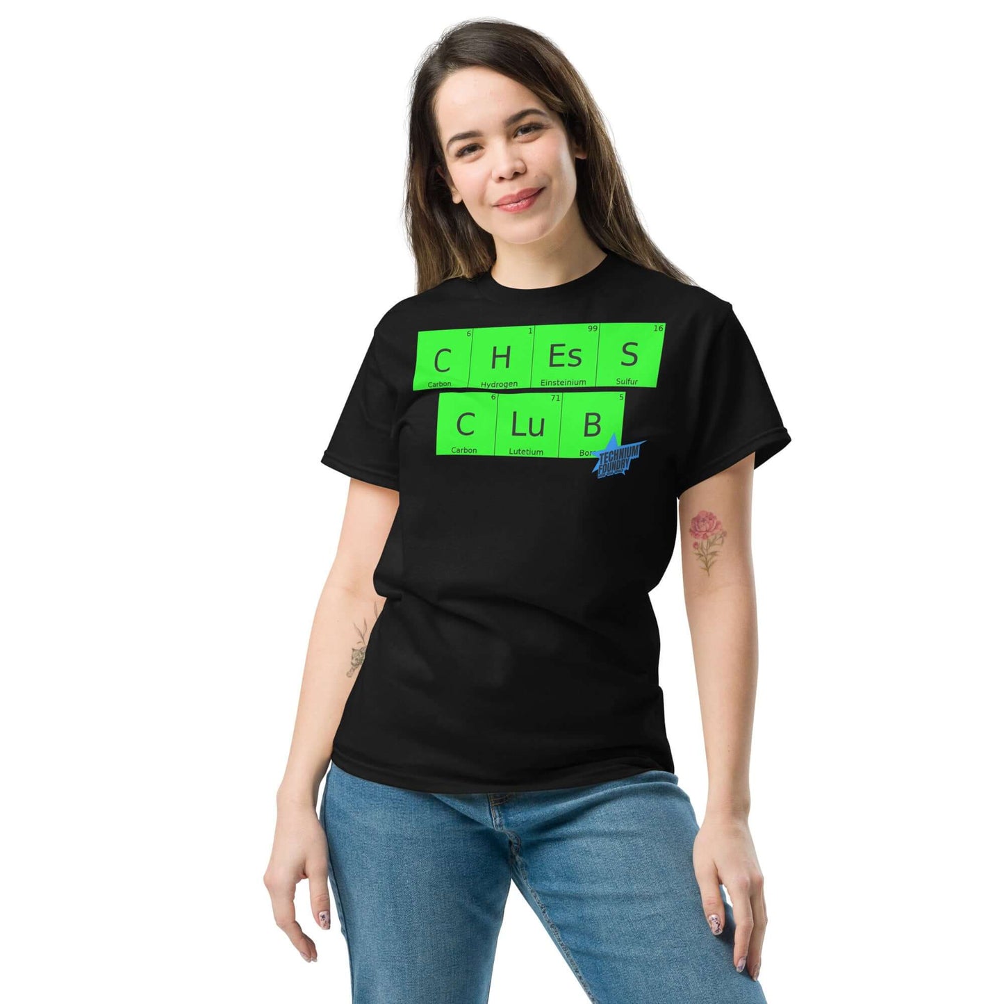 Woman wearing a black Chess Club T-shirt by Technium Foundry, featuring periodic table design blending chess and chemistry elements.