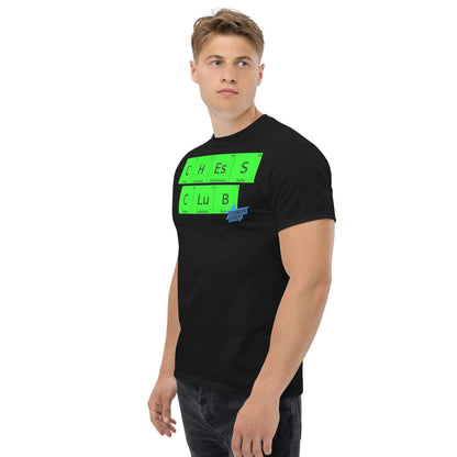 Man wearing black Chess Club T-shirt by Technium Foundry featuring green periodic table elements design, side view.