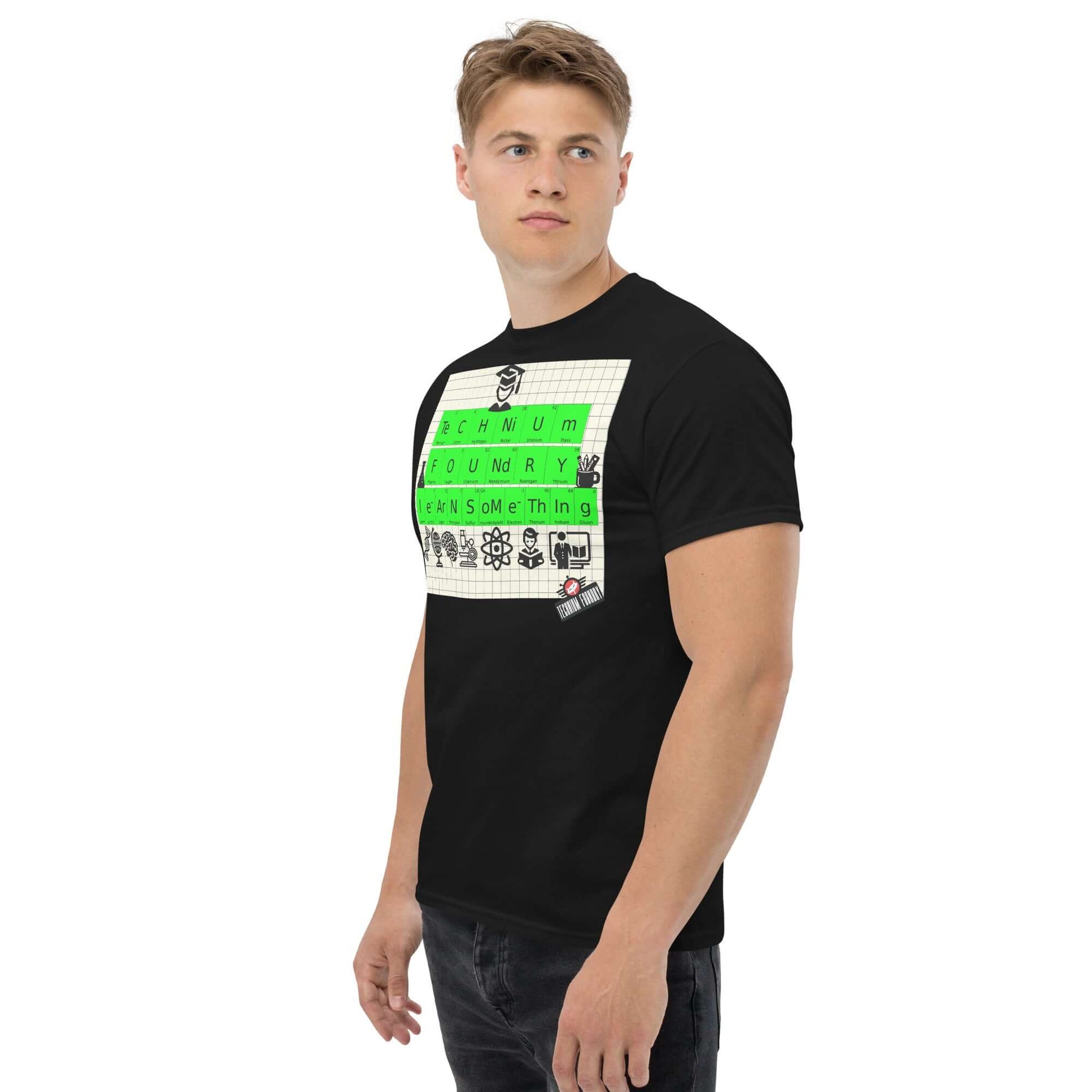 Man wearing Technium Foundry T-shirt with periodic table design and educational icons on classic graph paper background.