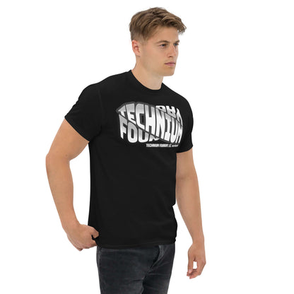 Man wearing black Technium Foundry Core Logo T-Shirt with bold typography design, perfect for science geeks and quantum apparel lovers.