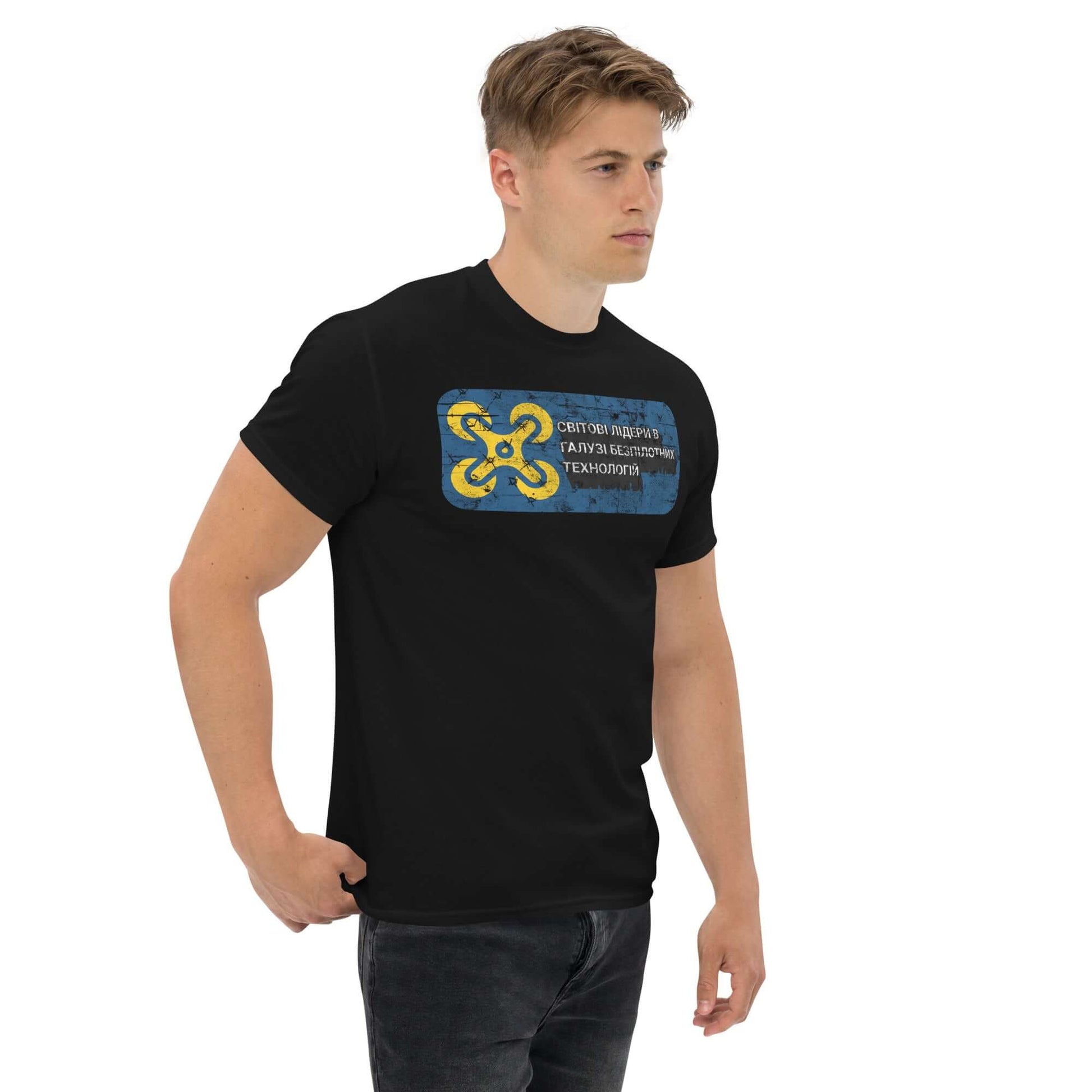 Man wearing a Ukrainian tech innovation t-shirt with Cyrillic drone design and blue-yellow emblem, symbolizing expertise in unmanned technologies.