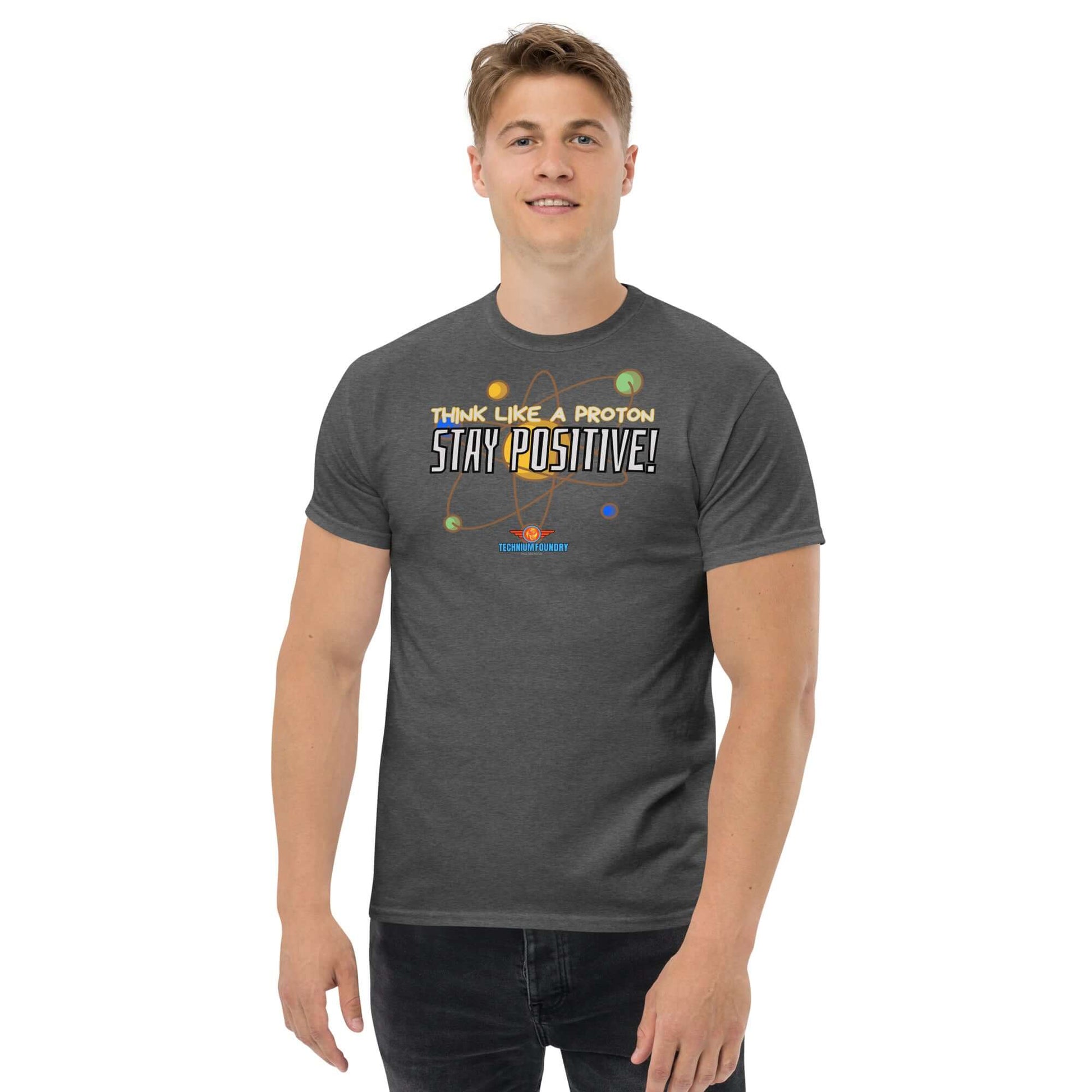 "Think Like a Proton, Stay Positive! Tee featuring particle physics humor on a motivational shirt, worn by a smiling model."