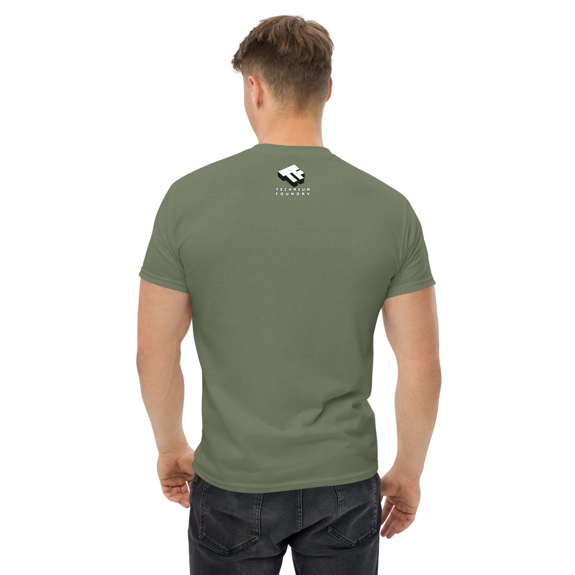 Back view of man wearing an olive green Space Tourist T-Shirt with white logo, casual jeans, standing against a plain background.