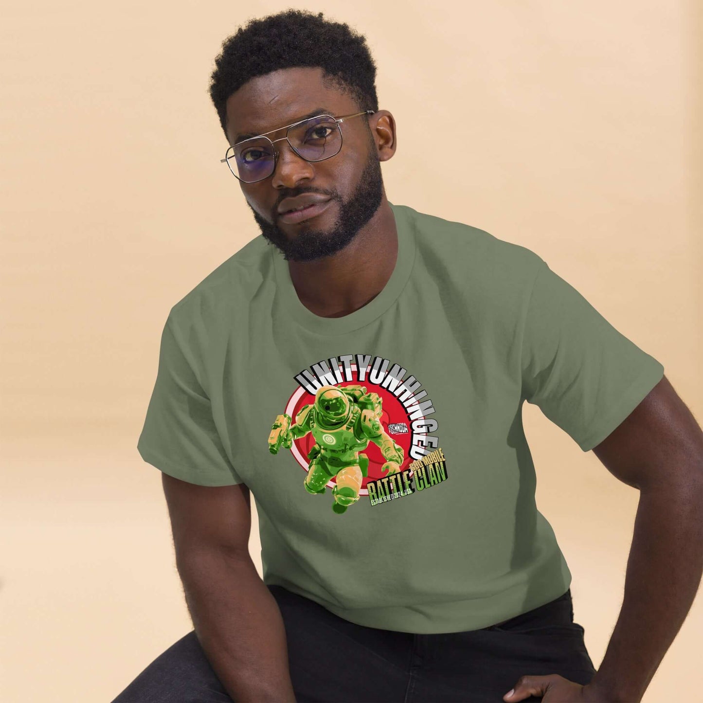 Man wearing UNITYUNHINGED Battle Clan T-Shirt by Technium Foundry, featuring a green combat-ready astronaut design.