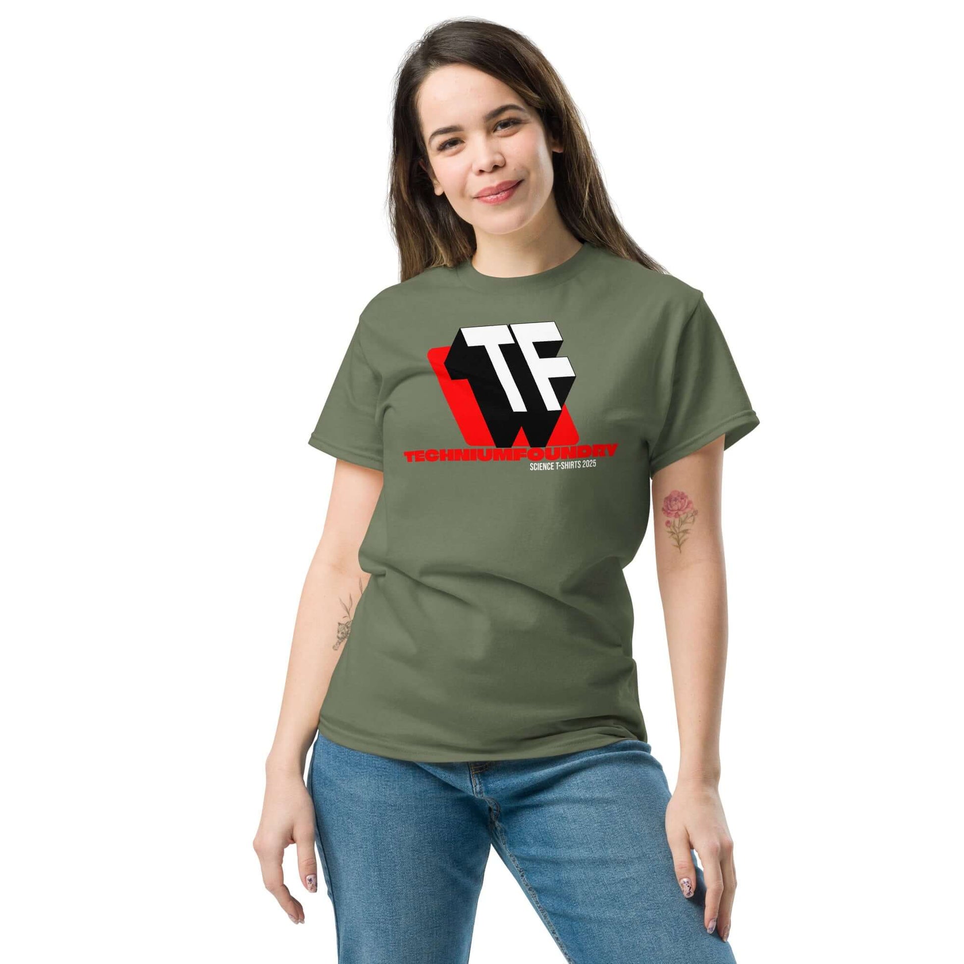 Woman wearing an olive green T-shirt with bold TF logo, red accents, and Technium Foundry text design.