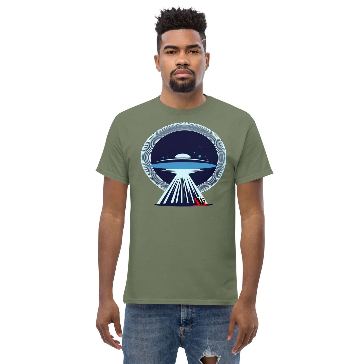 Man wearing olive green UFO Christmas T-Shirt by Technium Foundry, featuring a festive UFO design with a red sleigh in the tractor beam.