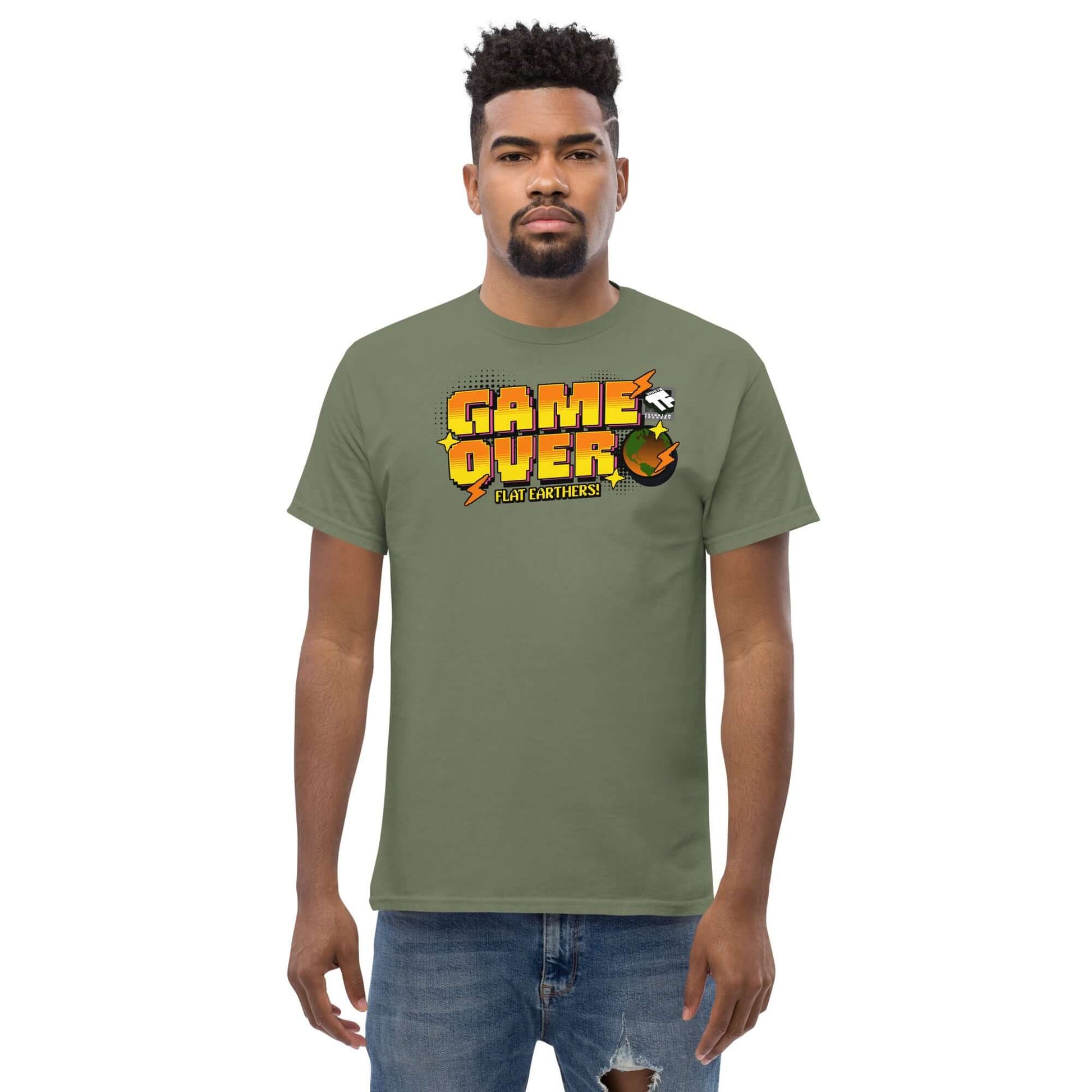 Olive green T-shirt with "Game Over Flat Earthers" pixel art design by Technium Foundry, featuring a round Earth and colorful graphics.