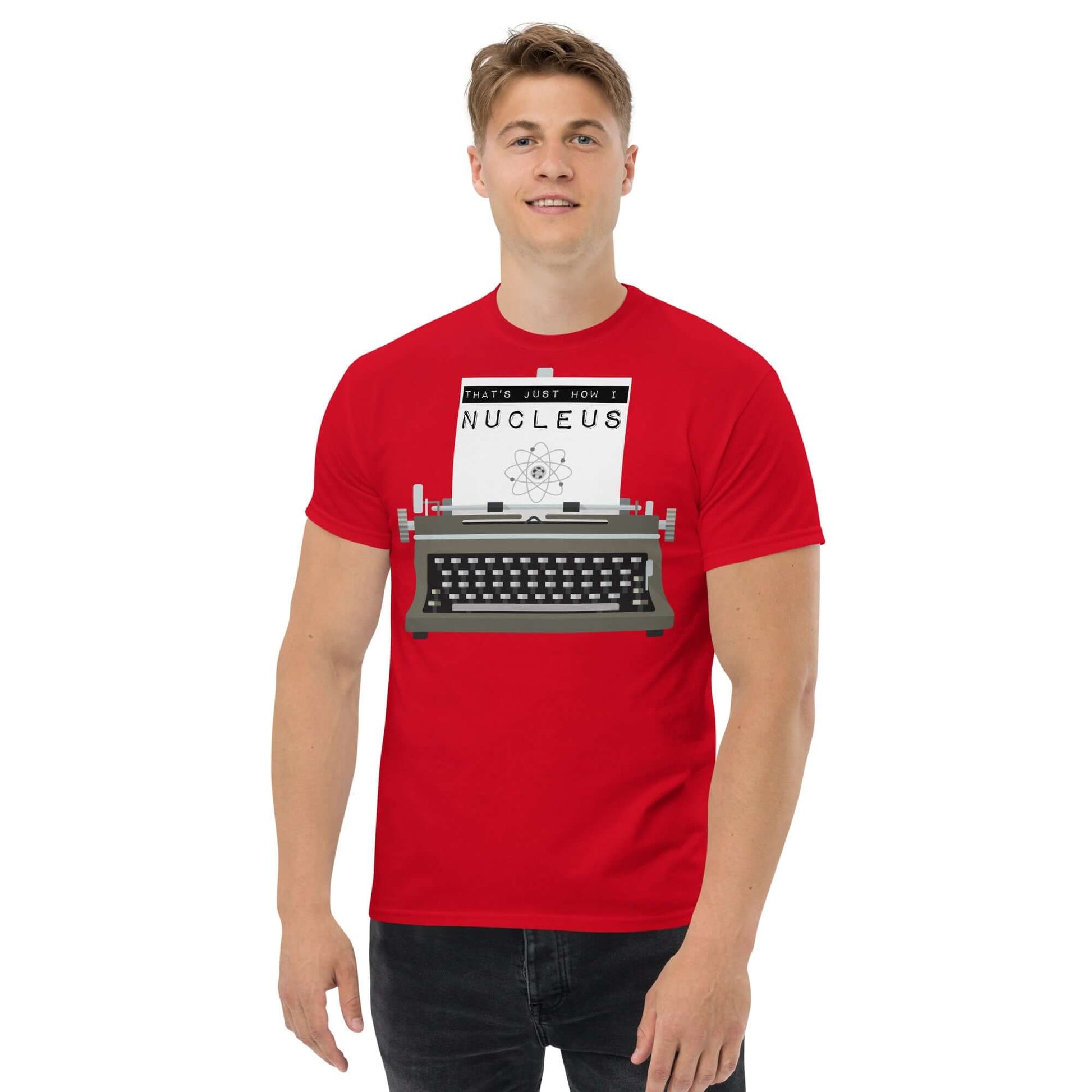 Man wearing red "That's Just How I Nucleus" tee with typewriter and atom design, blending nuclear physics and vintage style.