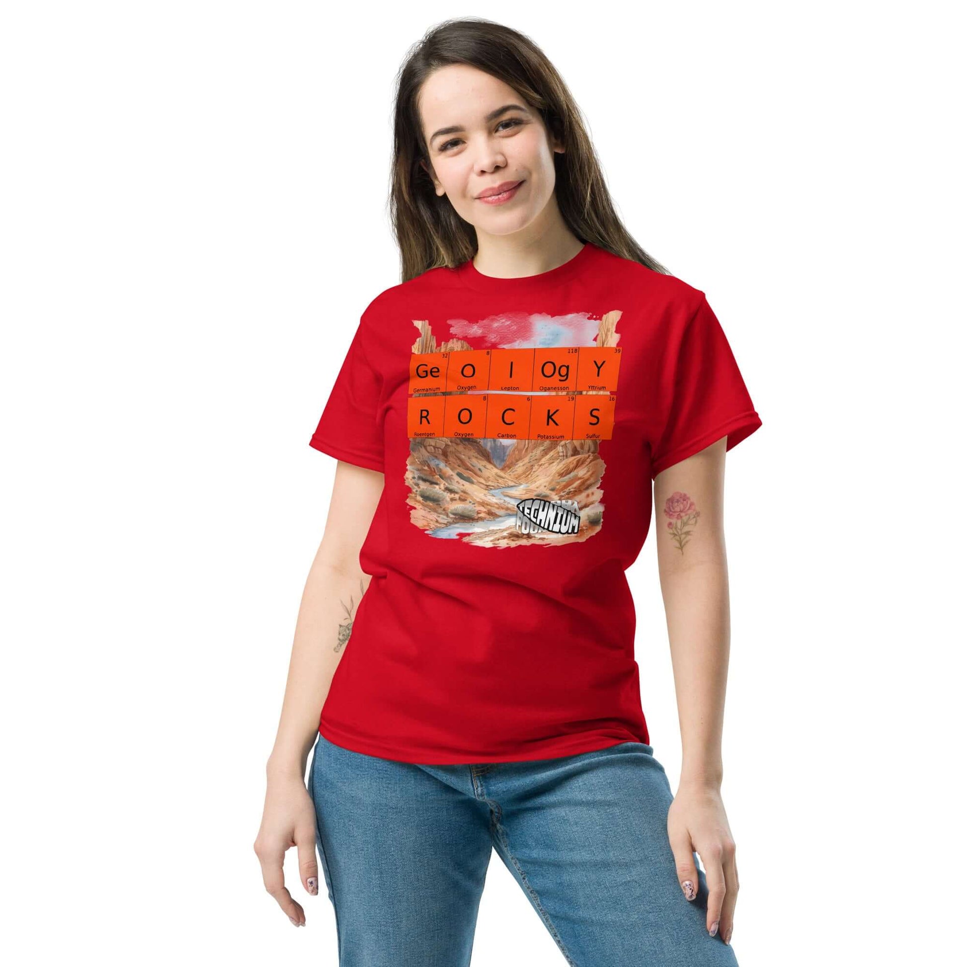 Woman wearing a red "Geology Rocks" T-shirt by Technium Foundry with periodic elements and a rocky landscape design.