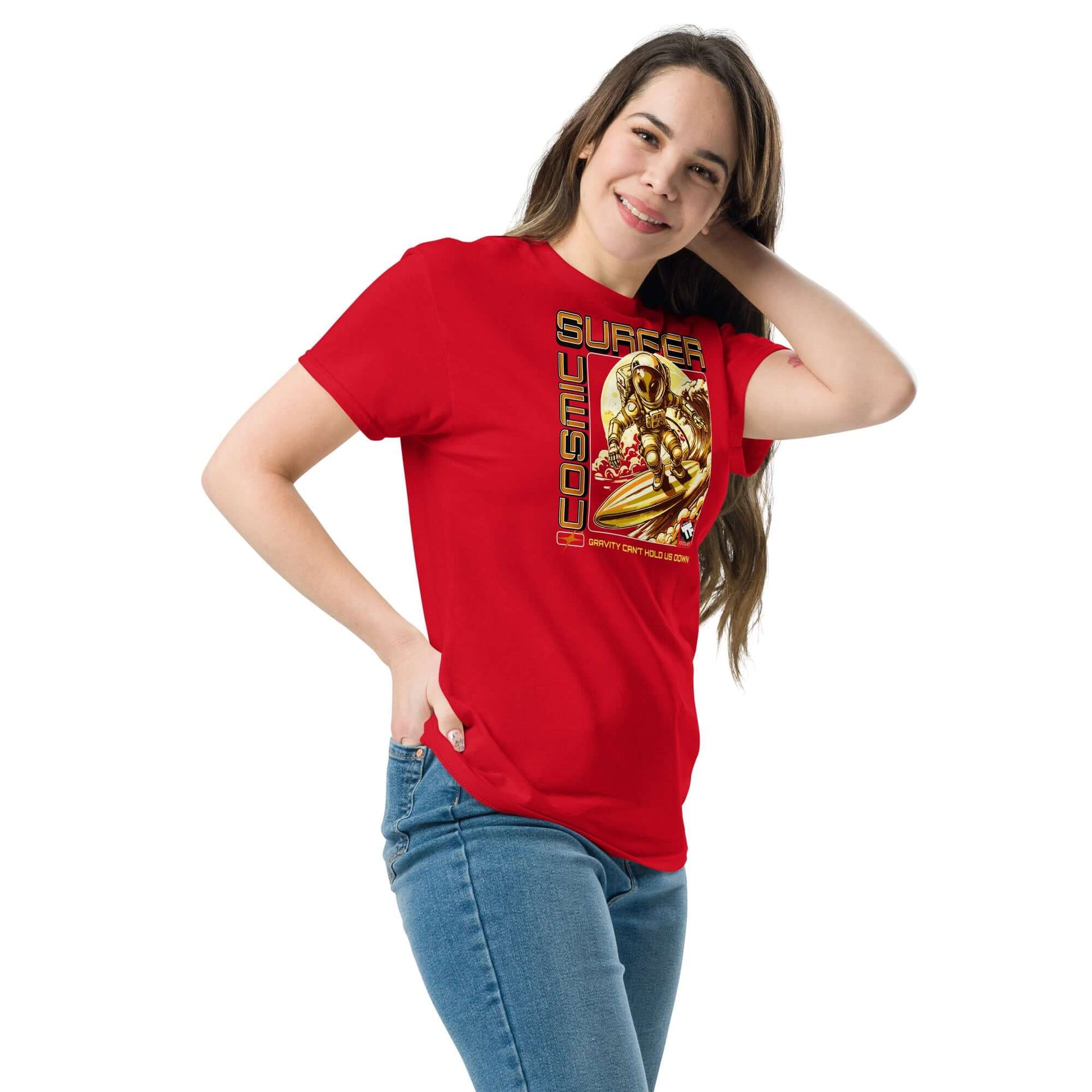 Smiling woman wearing a red "Cosmic Surfer" t-shirt featuring an astronaut surfing in space, with the tagline "Gravity Can't Hold Us Down."