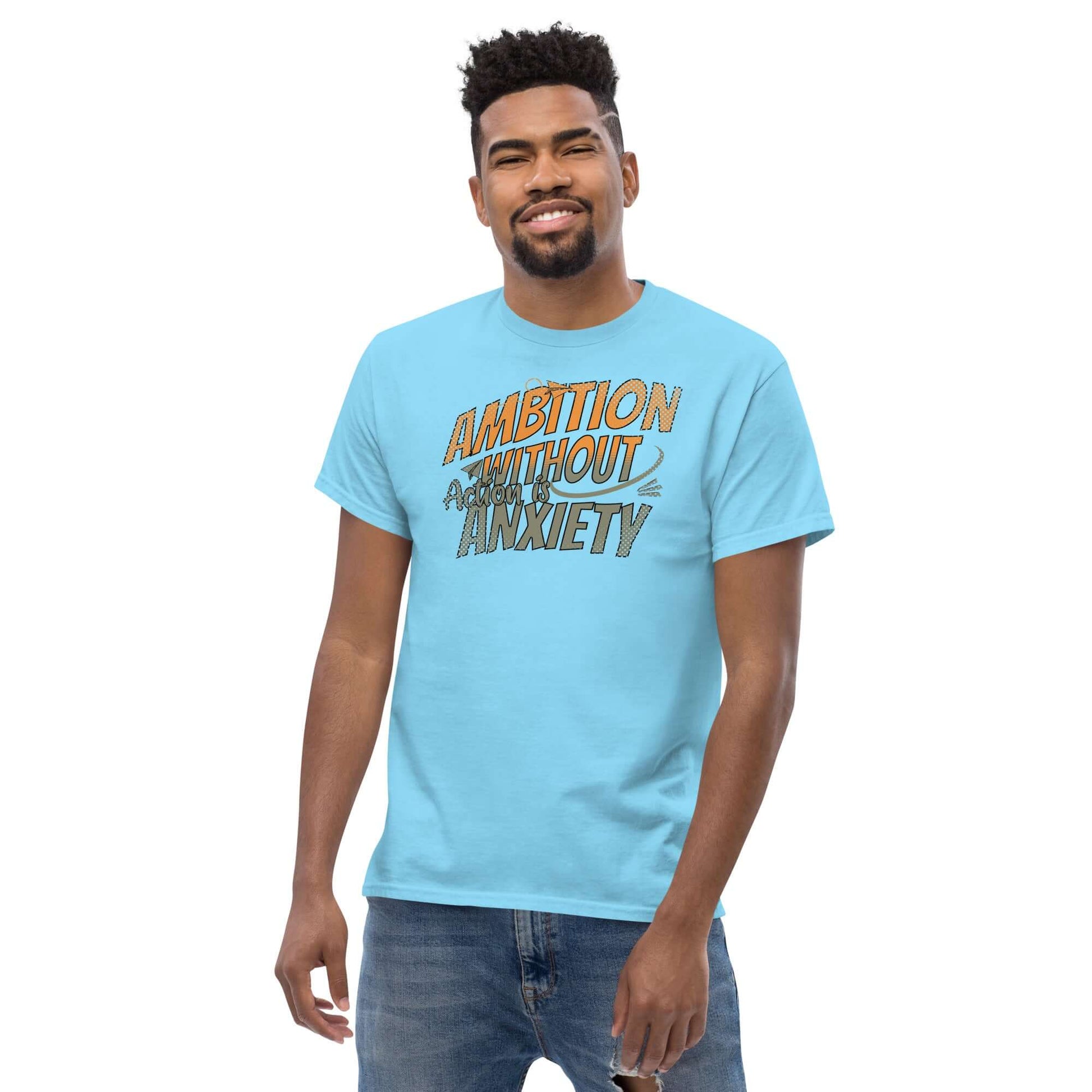 Person wearing Ambition Without Anxiety T-shirt, aspirational mental health humor in blue, bold typography, casual outfit.