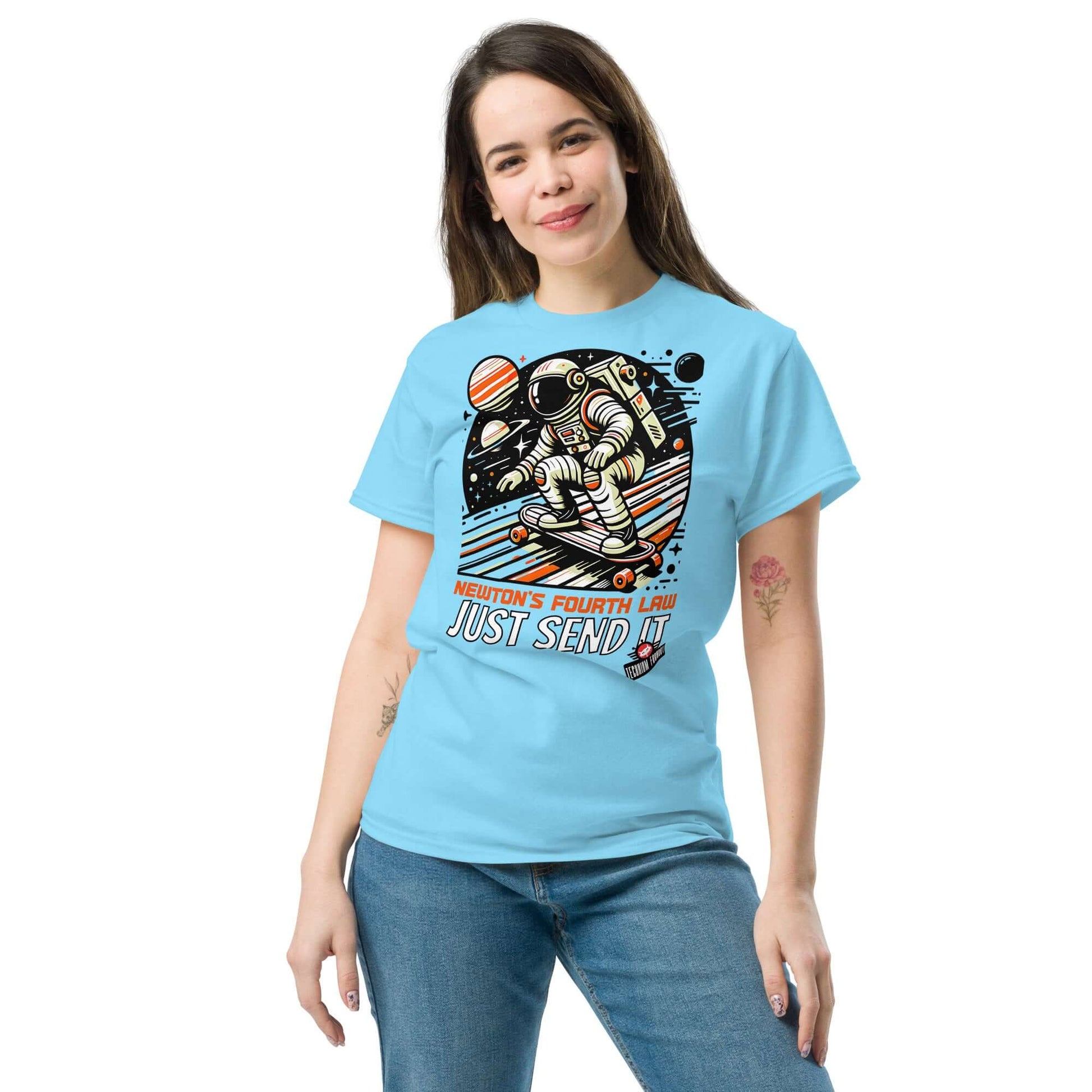 Woman wearing "Newton's Fourth Law: Just Send It" T-shirt by Technium Foundry, featuring a cosmic skater and planets design.