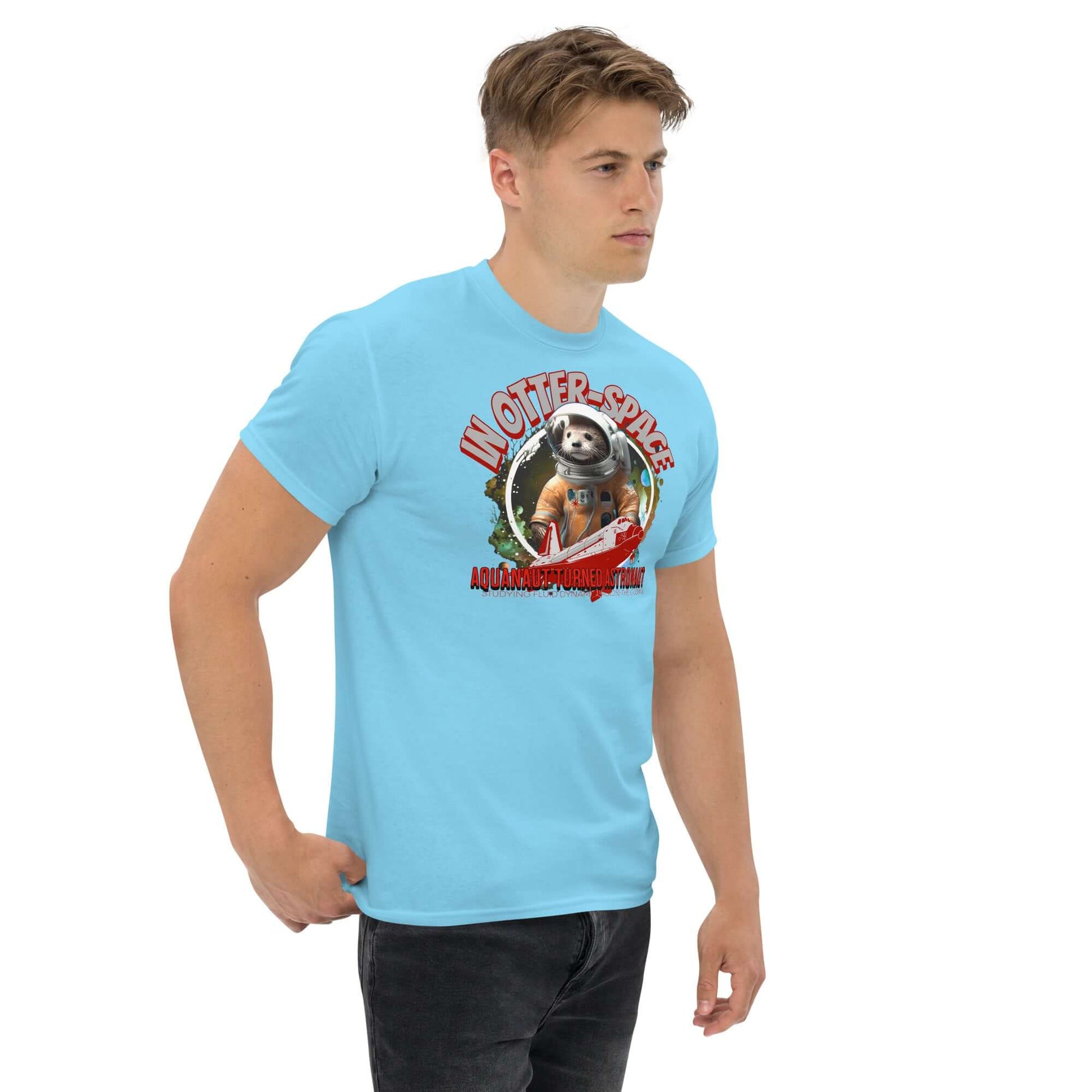 Man wearing "In Otter Space: Aquanaut Turned Astronaut" t-shirt featuring otter in spacesuit with shuttle and cosmic background.