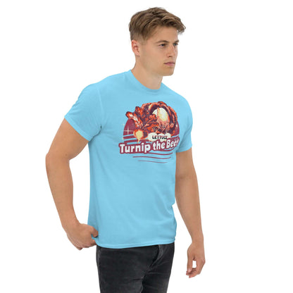 Man wearing blue T-shirt featuring "Lettuce Turnip the Beet" pun design with sunset backdrop and vintage vegetable illustration.