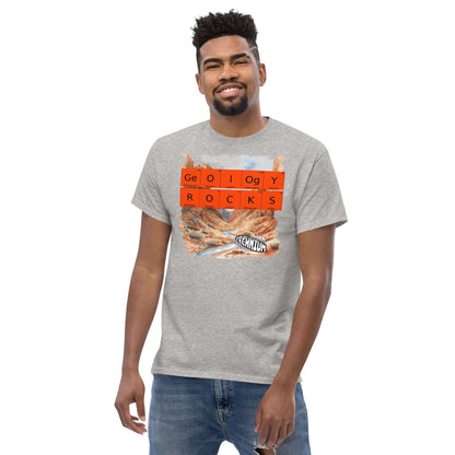 Man wearing GEOLOGY ROCKS T-shirt by Technium Foundry with periodic elements design and scenic rock formation background.