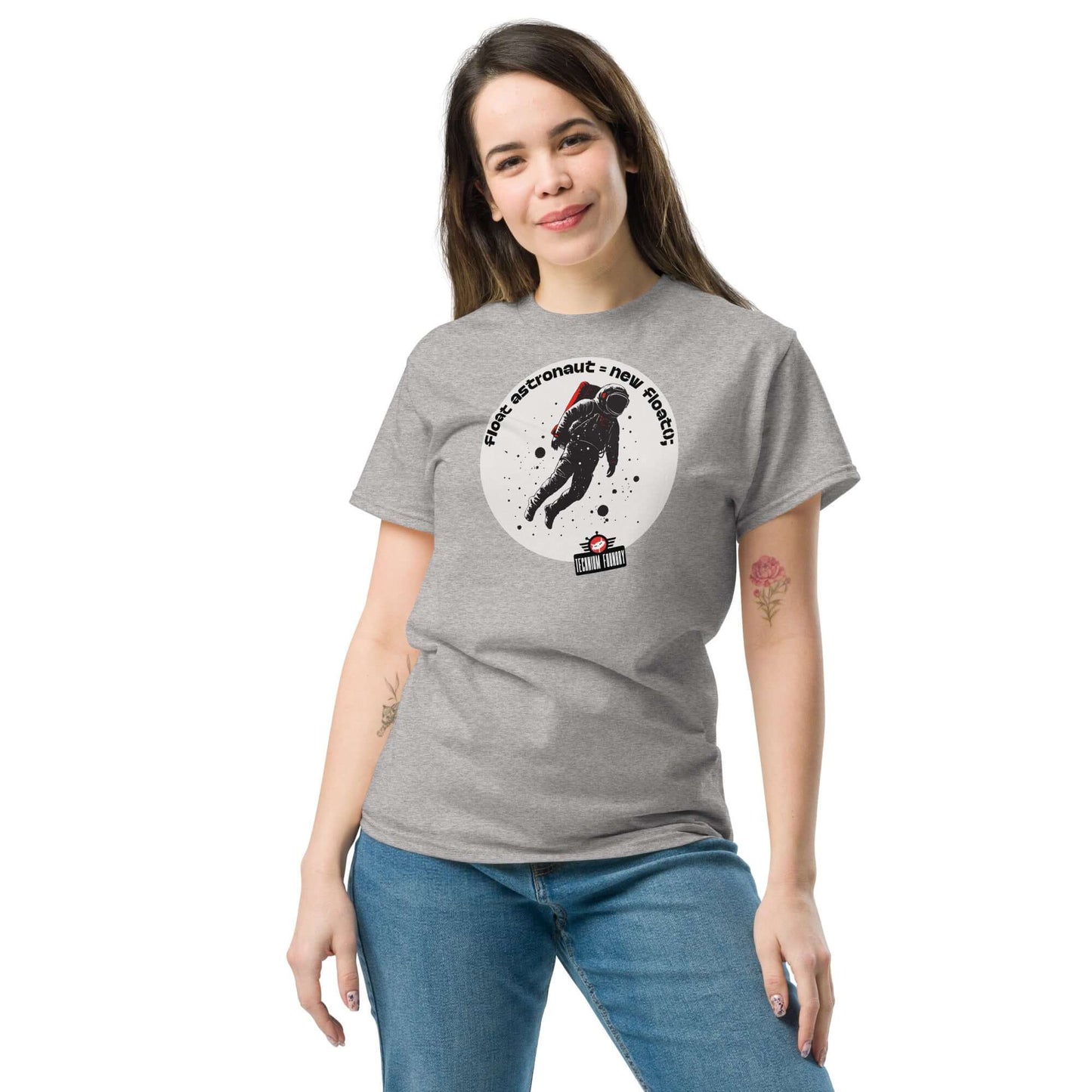 Woman wearing a grey t-shirt featuring an astronaut and code-themed design, titled "First Astronaut = New Branch()" by Technium Foundry.