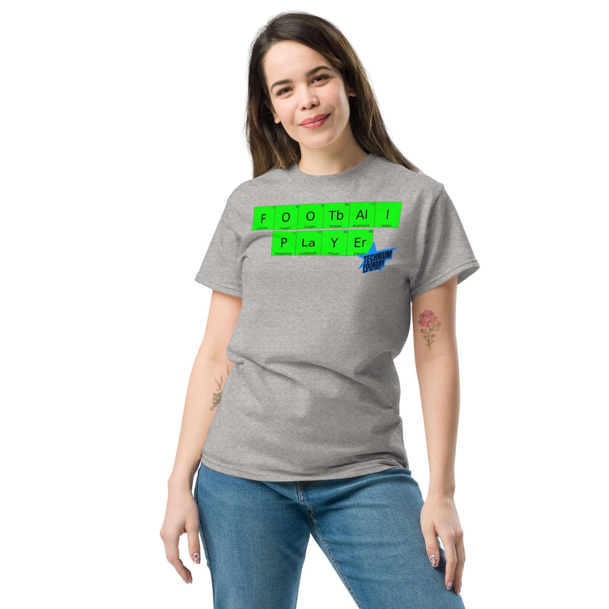 Woman wearing Technium Foundry football player t-shirt with periodic table design, combining sports and science elements.