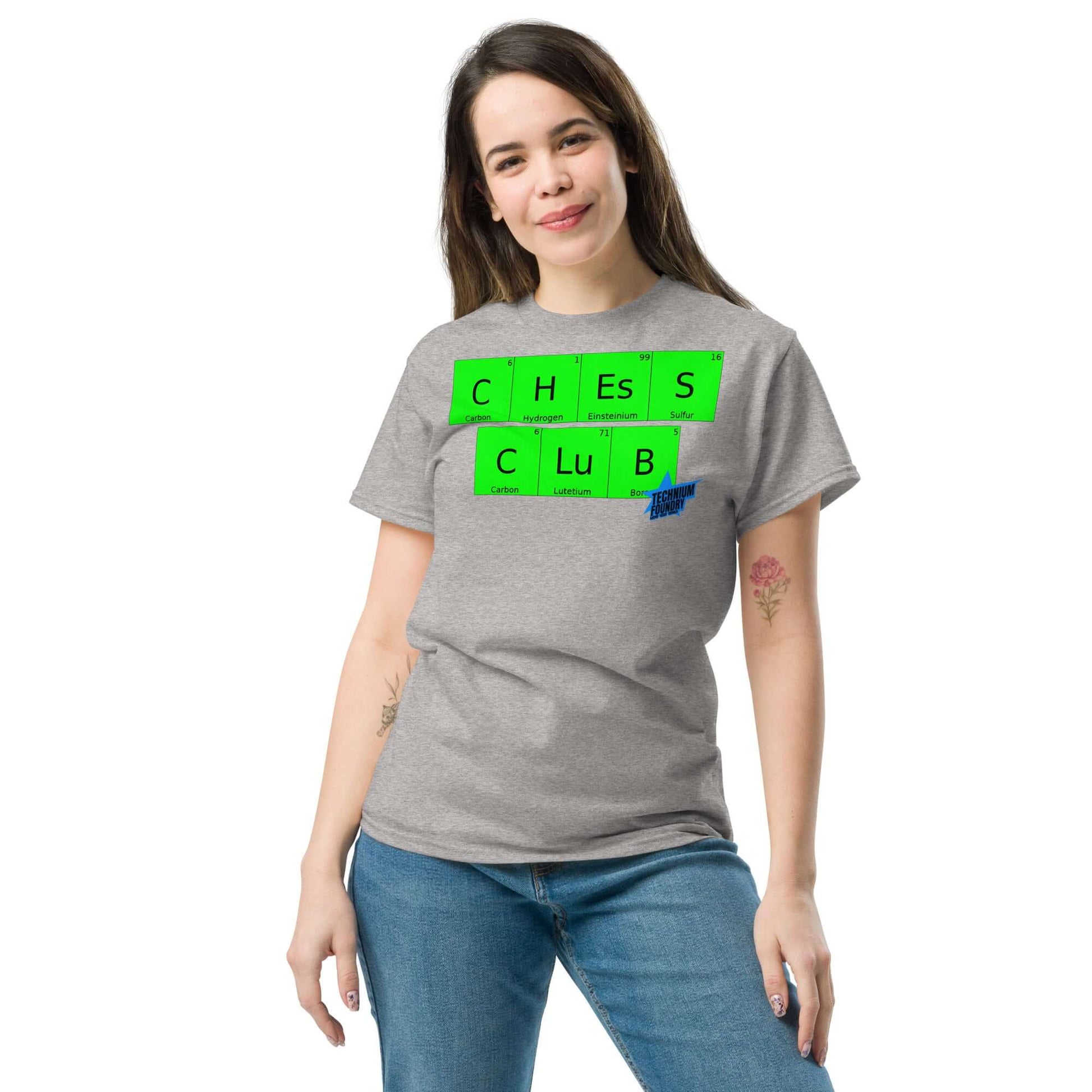 Woman wearing Technium Foundry Chess Club T-Shirt with chemical element design, mixing chess and chemistry on a soft gray fabric.