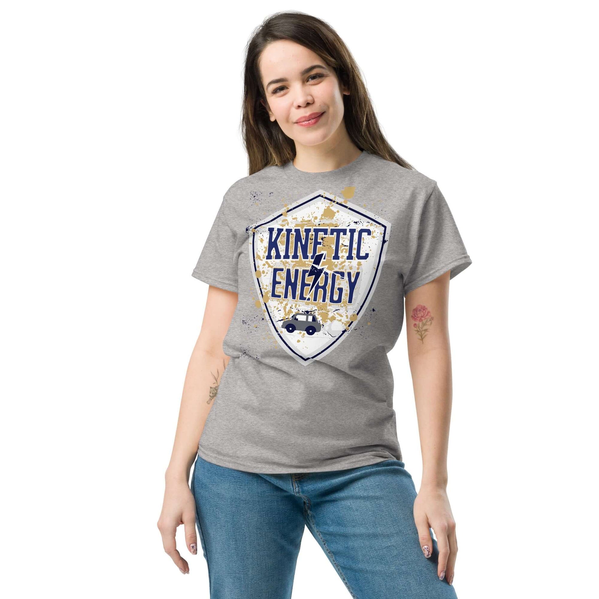 Woman wearing a grey Kinetic Energy T-shirt with vintage shield design and tiny car graphic, highlighting the concept of mass times velocity squared.