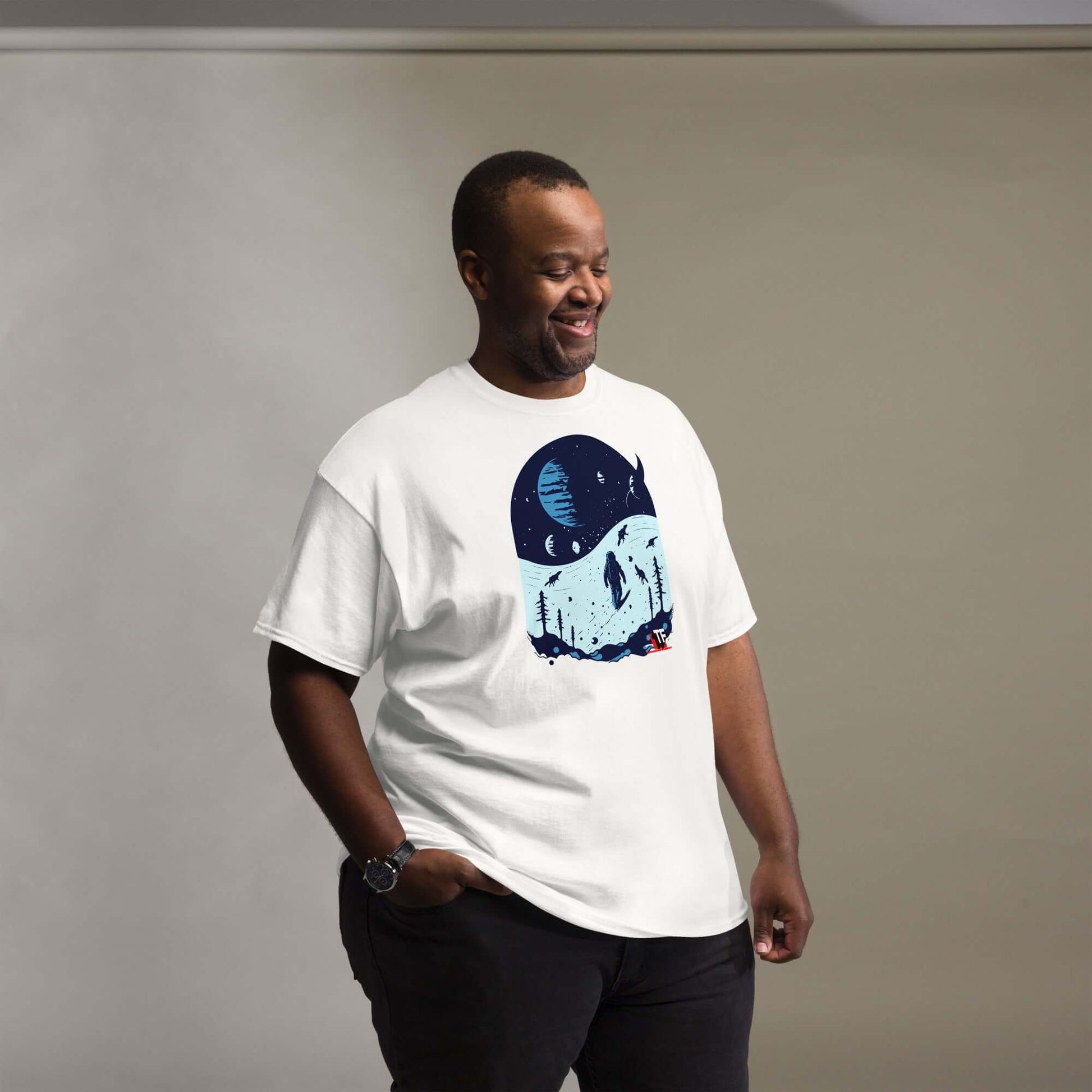 Space Dinosaur Slopes T-Shirt featuring astronaut and T-Rex skiing on an alien planet, modeled on a smiling person indoors.