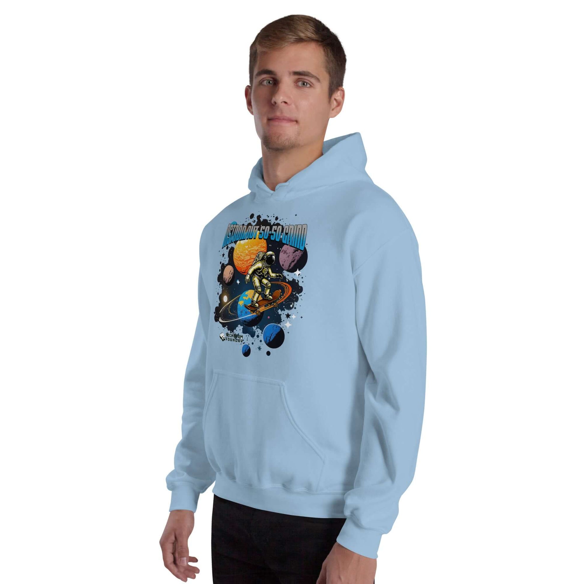 Astronaut 50-50 Grind Hoodie featuring cosmic skater and Saturn graphic by Technium Foundry, modeled with a light blue background.