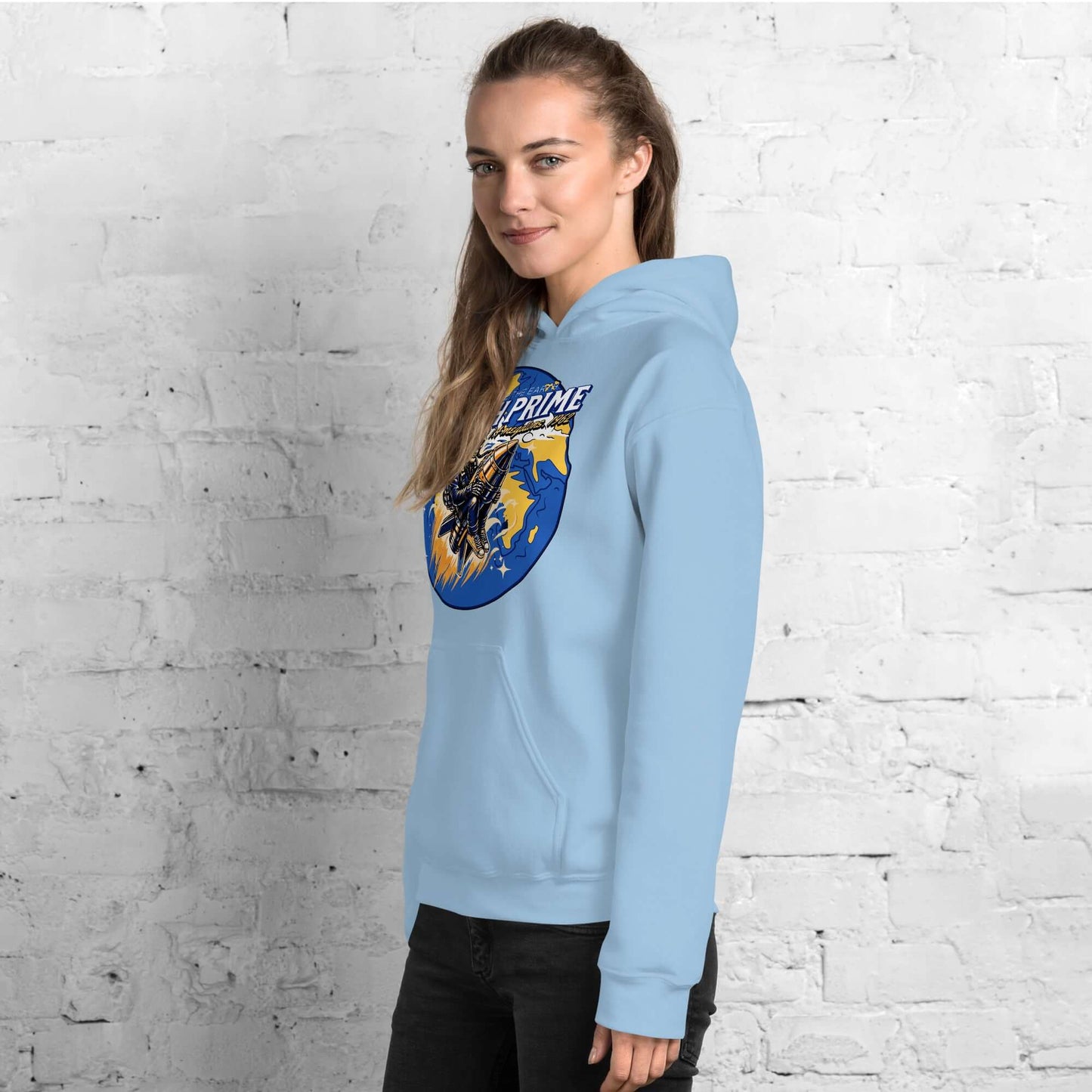 Woman wearing Starfish Prime Hoodie with retro nuclear space test design against a white brick wall.