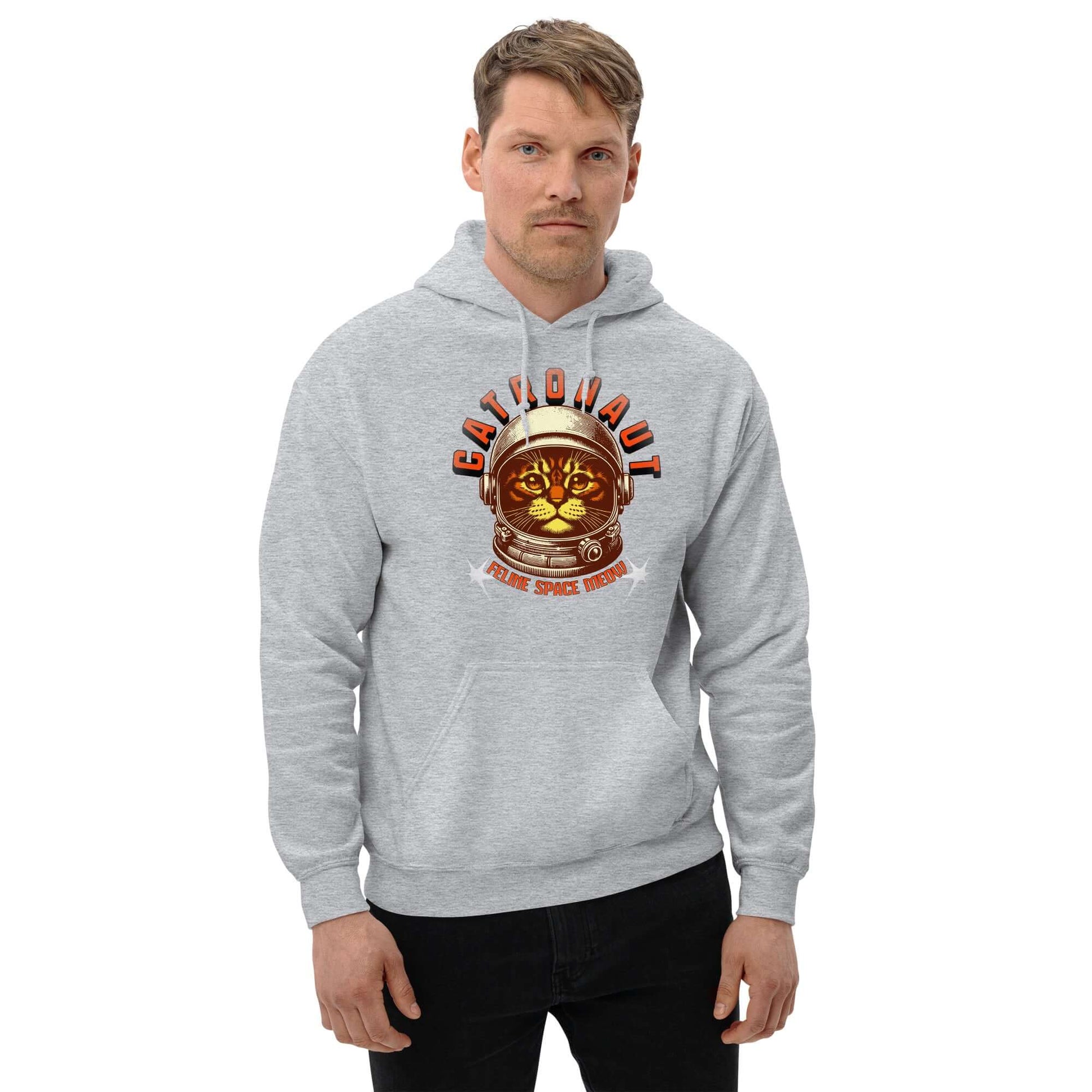 Man wearing Catronaut Hoodie in gray, featuring a cat in space helmet design, Mission Control Edition by Technium Foundry.