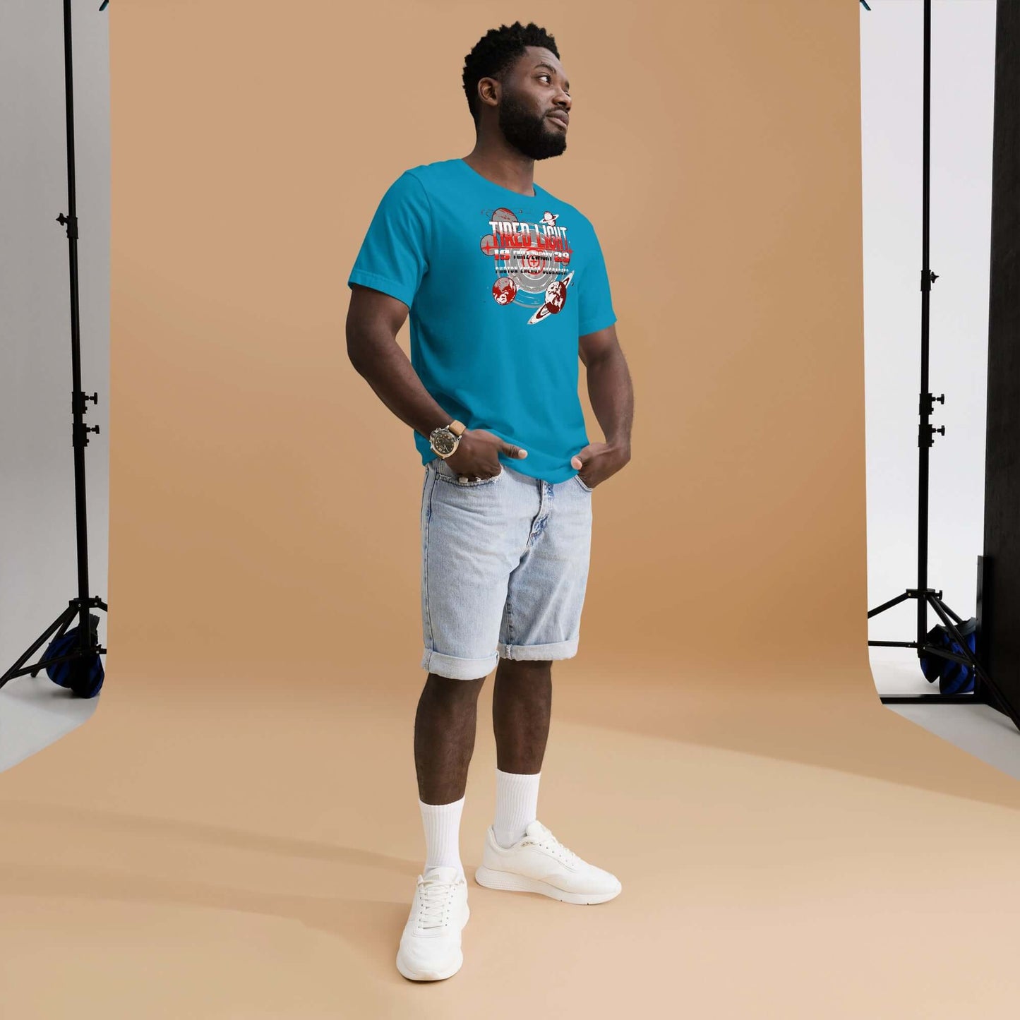 Man wearing Tired Light T-Shirt with retro sci-fi design, celebrating cosmic hypothesis, standing in a photo studio.