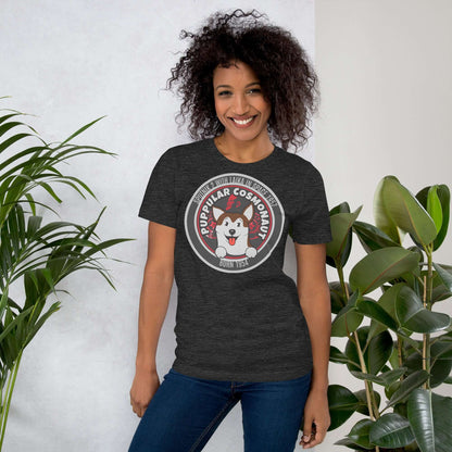 Woman wearing Puppular Cosmonaut T-Shirt featuring Laika the space dog, standing next to plants, smiling and showcasing retro design.