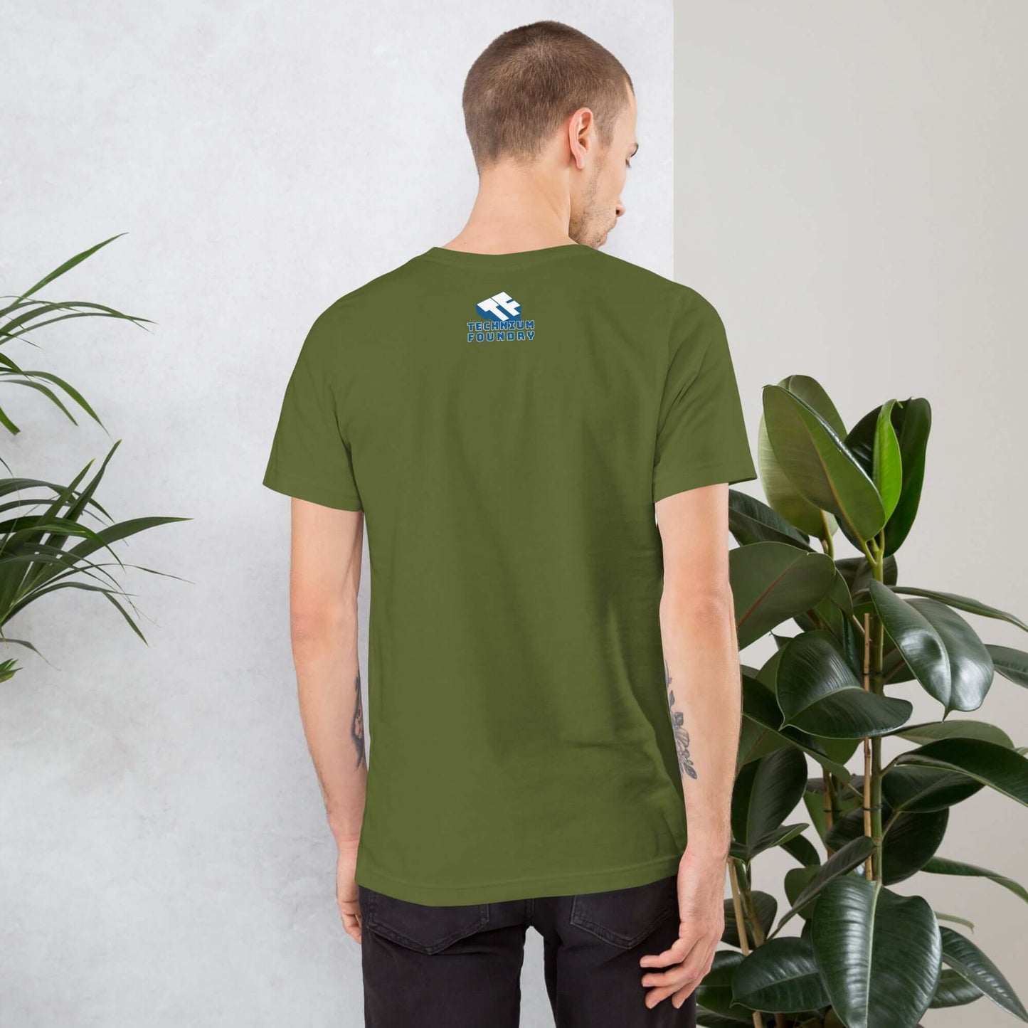 Man wearing E-SK8 Till My Battery Dies green t-shirt, back view, standing near plants