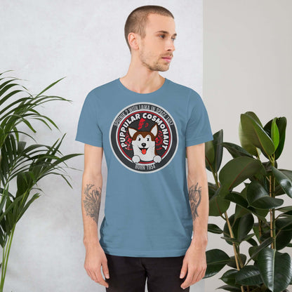 Man wearing a blue Puppular Cosmonaut T-Shirt featuring Laika, the space dog with a retro emblem design.