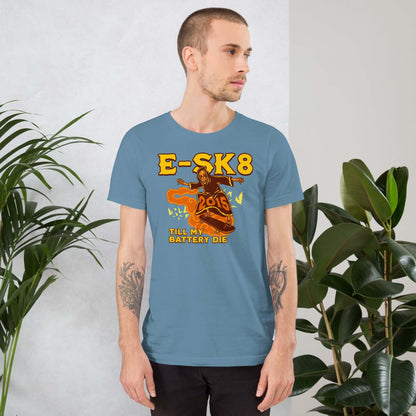 Man wearing E-SK8 Till My Battery Dies T-Shirt with Grim Reaper design in yellow, standing next to plants.