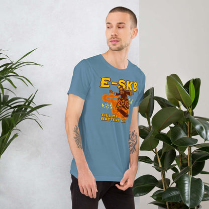 Man wearing E-SK8 Till My Battery Dies t-shirt with Grim Reaper design, standing next to plants in a modern setting.