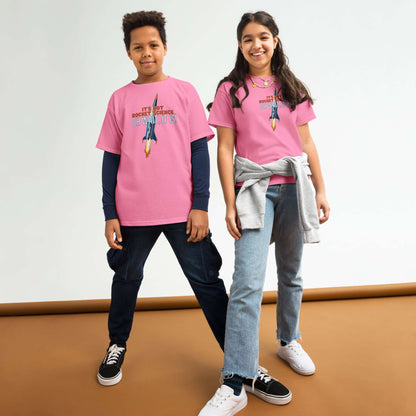 Two kids wearing "It's Not Rocket Science" pink tees, featuring a comic rocket design, standing confidently in casual outfits.