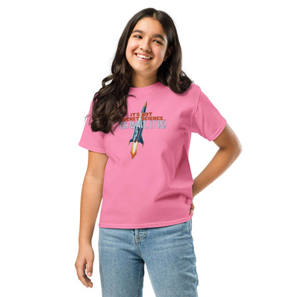 Girl wearing pink tee with "It's Not Rocket Science... Oh Wait, It Is!" design featuring a rocket and text. Casual and playful fashion.