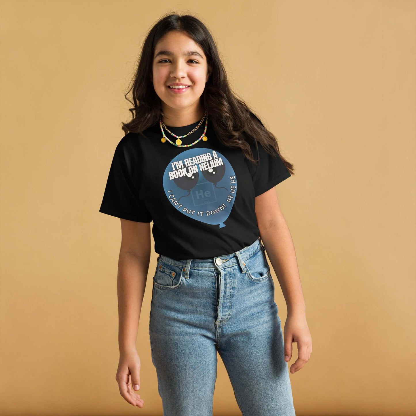 Teen girl wearing a black T-shirt featuring a pun with helium balloons and text "I'm Reading a Book on Helium - I Can't Put It Down!"